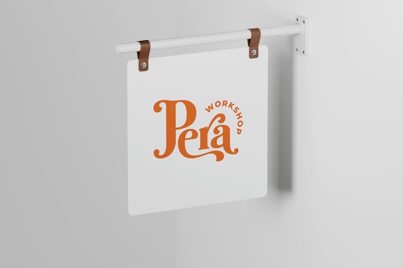 May include: A white sign with brown leather straps hanging from a white metal rod. The sign has the text "Workshop Pera" in orange lettering.