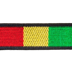 May include: A black, red, yellow, and green embroidered patch. The patch is rectangular and has a black border.