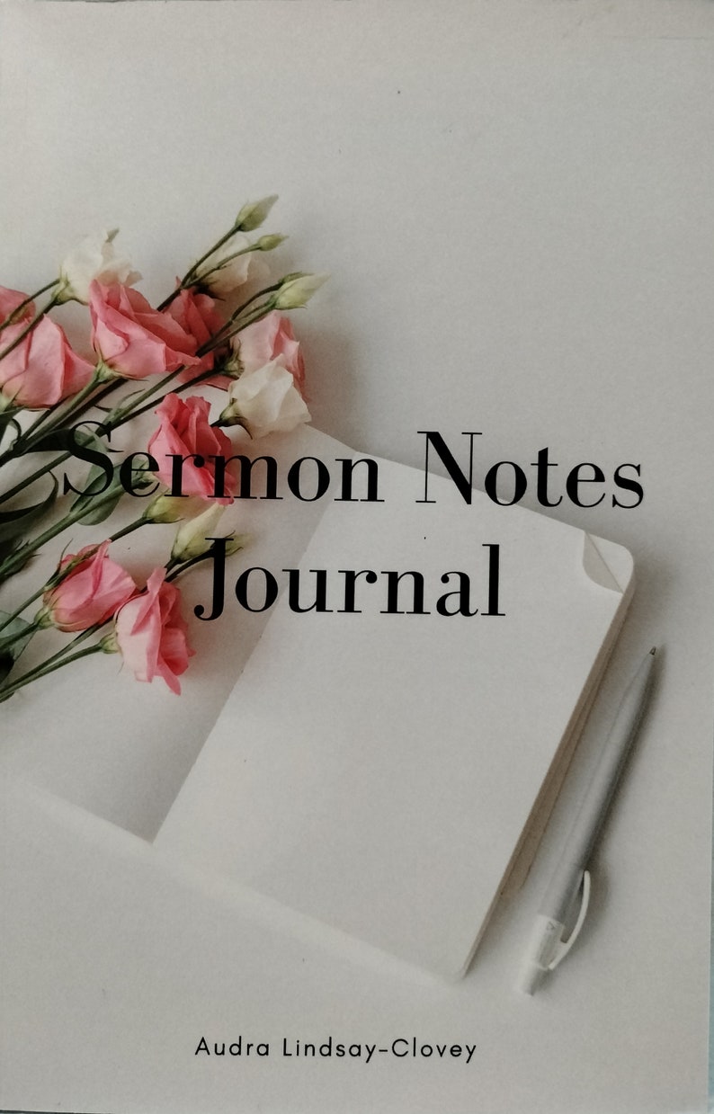 Pu&ograve; includere: Un diario bianco con il testo "Sermon Notes Journal" e il nome "Audra Lindsay-Clovey" stampato sulla copertina. Fiori rosa e bianchi e una penna argentata sono sul diario.