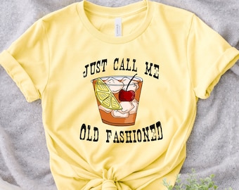 May include: Yellow t-shirt with the text "Just Call Me Old Fashioned" and a graphic of an old fashioned cocktail.
