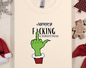 May include: A cream-colored t-shirt with a green hand giving the middle finger and the text "Merry F*cking Christmas".