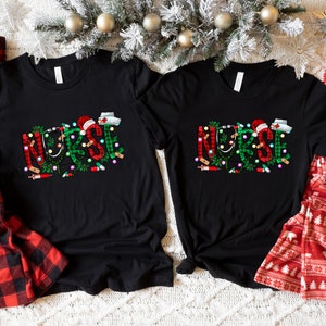 May include: Two black t-shirts with the word "NURSE" spelled out in green and red with Christmas lights and medical symbols. The shirts are on a white fuzzy surface with red and black plaid pajamas and red and white pajamas with a white mug.
