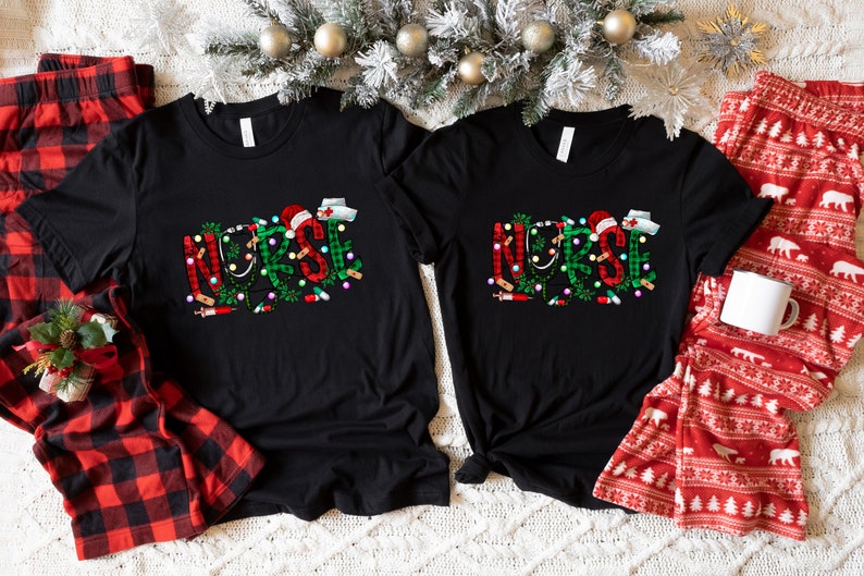 May include: Two black t-shirts with the word "NURSE" spelled out in green and red with Christmas lights and medical symbols. The shirts are on a white fuzzy surface with red and black plaid pajamas and red and white pajamas with a white mug.