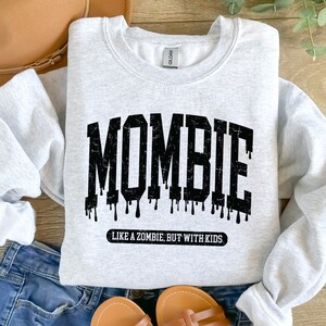 May include: A gray sweatshirt with the text "MOMBIE LIKE A ZOMBIE BUT WITH KIDS" in black.
