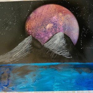 Purple and red planet, behind a  mountain range, behind an ocean river.