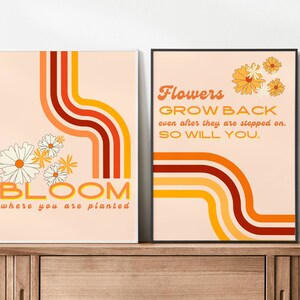 May include: Two motivational posters with a retro 70s aesthetic. The first poster features a peach background with orange, red, and yellow curved lines and white daisies. The text reads "BLOOM where you are planted". The second poster features a peach background with orange, red, and yellow curved lines and yellow daisies. The text reads "Flowers GROW BACK even after they are stepped on. SO WILL YOU."
