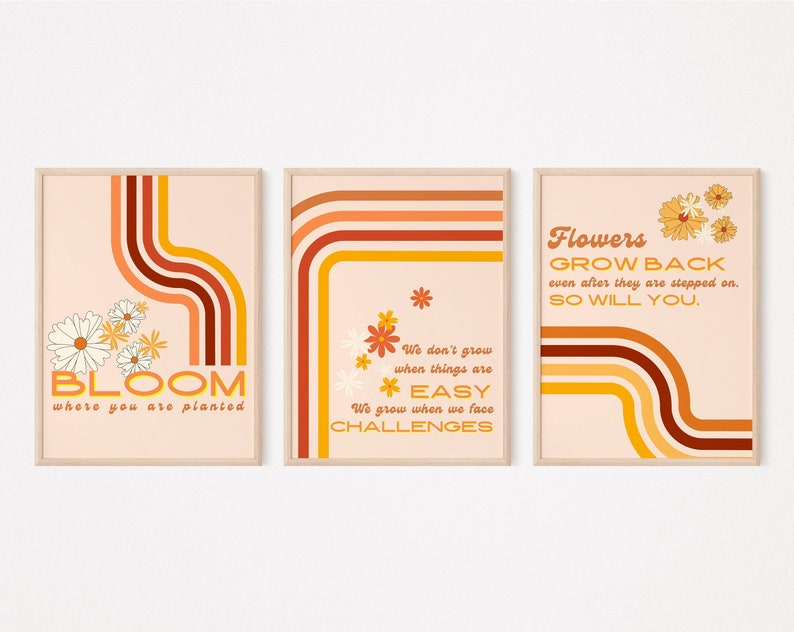 May include: Three printable wall art prints with a retro 70s design. The prints feature orange, yellow, and brown stripes with white daisies. The text on the prints reads "Bloom where you are planted", "We don't grow when things are easy. We grow when we face challenges", and "Flowers grow back even after they are stepped on. So will you."