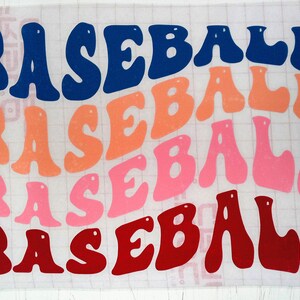 May include: Four layered vinyl stickers with the word "BASEBALL" in different colours. The top layer is navy blue, the second layer is orange, the third layer is pink, and the bottom layer is red.