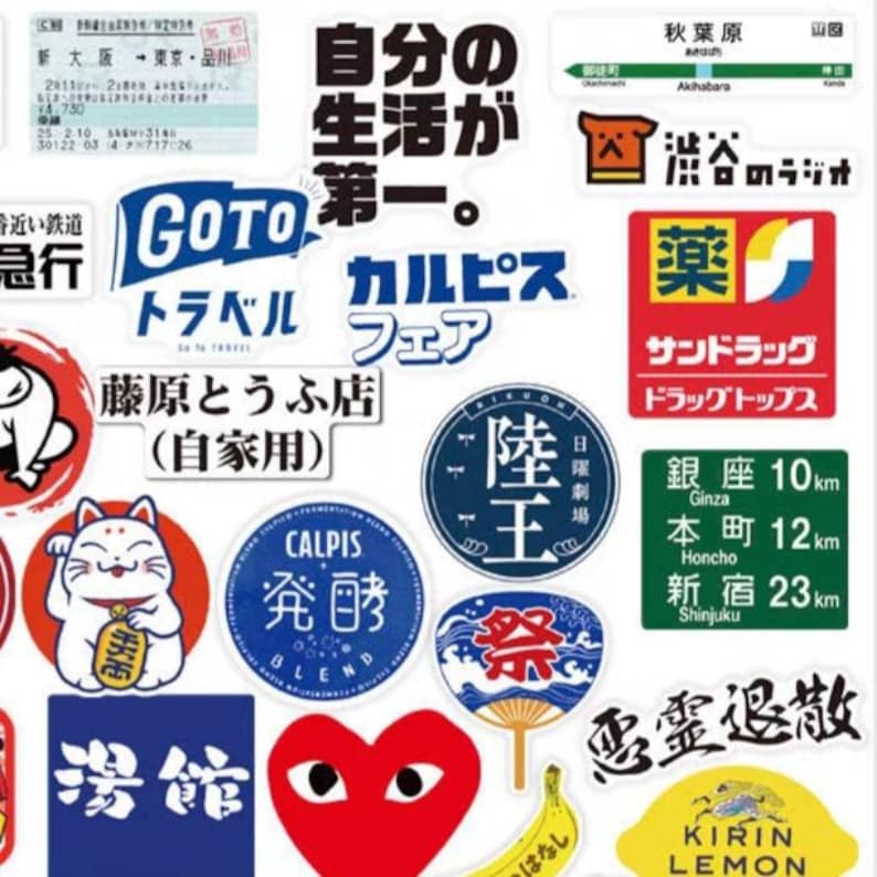 May include: A collection of colorful stickers featuring Japanese text, logos, and illustrations. The stickers include a red heart with eyes, a blue and white fan, a yellow banana, a yellow lemon with the text "KIRIN LEMON", and a blue and white sticker with the text "陸王".