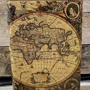 Op de afbeelding: Een vintage boekcover met een gedetailleerde wereldkaart. De cover heeft een warme, verouderde bruine kleur met ingewikkelde illustraties en portretten. De titel "HYDROGRAPHICA TABVLA" is zichtbaar aan de bovenkant.