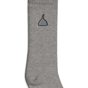 May include: Gray crew socks with a small gray embroidered design of a hat on the front.