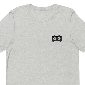 May include: A heather grey t-shirt with a black and white illustration of a clock with a red button on top.