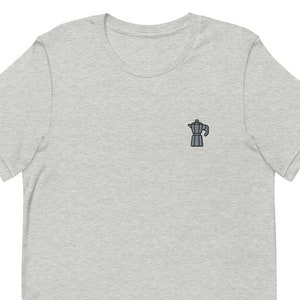 以下が含まれることがあります： ヘザーグレーのTシャツに、銀色のコーヒーポットの小さな刺繍が施されています。