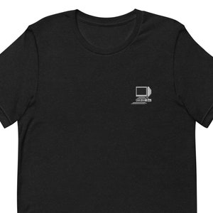 Puede incluir: Camiseta negra con un gráfico blanco de una computadora retro con el texto "ascii.im" debajo.