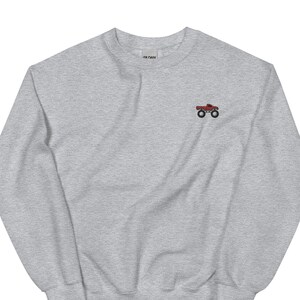 May include: A gray sweatshirt with a small red monster truck embroidered on the front.