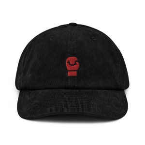 May include: A black corduroy baseball cap with a red embroidered boxing glove on the front.