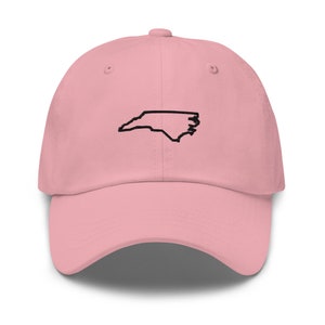 K&ouml;nnte beinhalten: Eine rosafarbene Baseballkappe mit einem gestickten Umriss des Bundesstaates North Carolina.