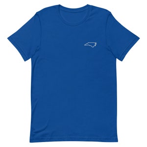 Puede incluir: Una camiseta de manga corta azul real con un contorno blanco del estado de Carolina del Norte en el pecho izquierdo.