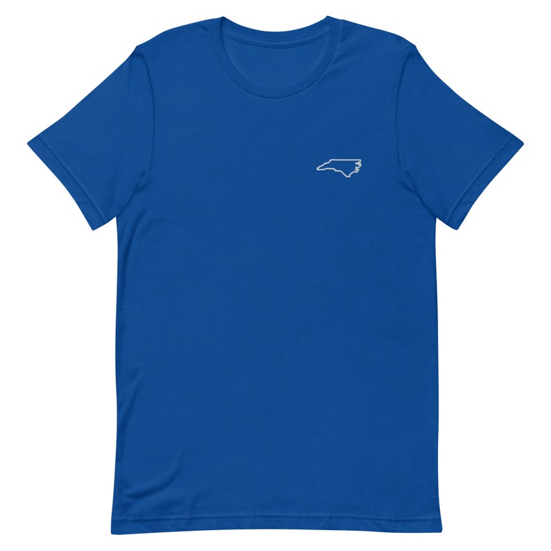 Puede incluir: Una camiseta de manga corta azul real con un contorno blanco del estado de Carolina del Norte en el pecho izquierdo.