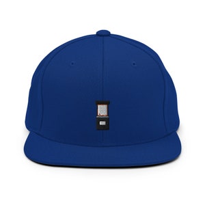 May include: A royal blue baseball cap with a black and white embroidered arcade game design.