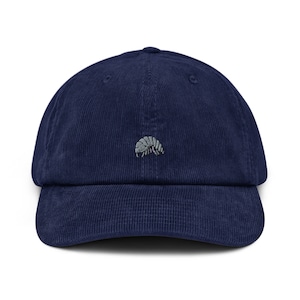 May include: A navy blue corduroy baseball cap with a curved brim. The cap features a small embroidered image of a pill bug on the front. The hat is a classic style, suitable for casual wear.