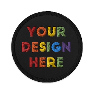 Może przedstawiać: Okrągła czarna łatka z wyszytym tekstem "YOUR DESIGN HERE" w kolorach tęczy.