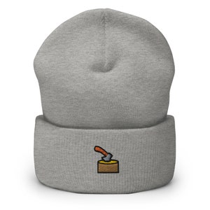 Puede incluir: Gorro gris con una pequeña imagen bordada de un hacha clavada en un tronco.