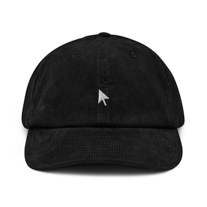 May include: A black corduroy baseball cap with a white embroidered arrow pointing to the right.