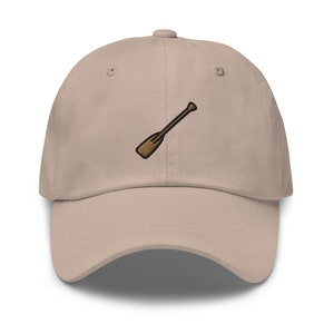 May include: A tan baseball cap with a brown embroidered oar design.