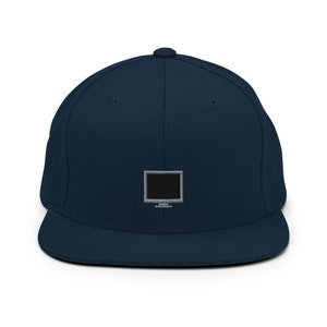 Puede incluir: Una gorra de béisbol azul marino con un gráfico de monitor de computadora en blanco y negro bordado en la parte delantera.