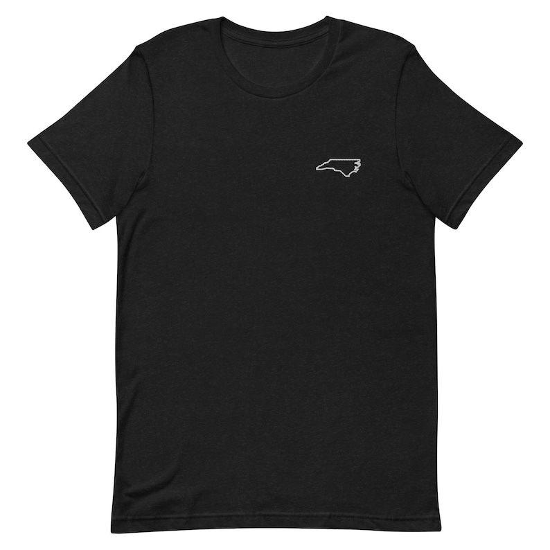 Puede incluir: Camiseta negra de manga corta con un contorno blanco del estado de Carolina del Norte.