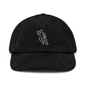 Op de afbeelding: Zwarte corduroy baseballcap met een gebogen klep. De cap heeft een witte geborduurde omtrek van een persoon. Een hoed in klassieke stijl, geschikt voor vrijetijdskleding.