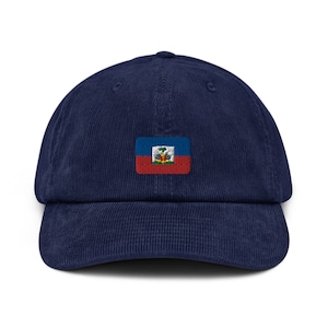 May include: A navy blue corduroy baseball cap with an embroidered flag of Haiti on the front.