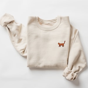 オレンジ色の猫の刺繍入りスウェットシャツ - タビークルーネック、カスタムハンドメイドユニセックスセーター、かわいい猫好きへのギフト、複数のカラーオプション