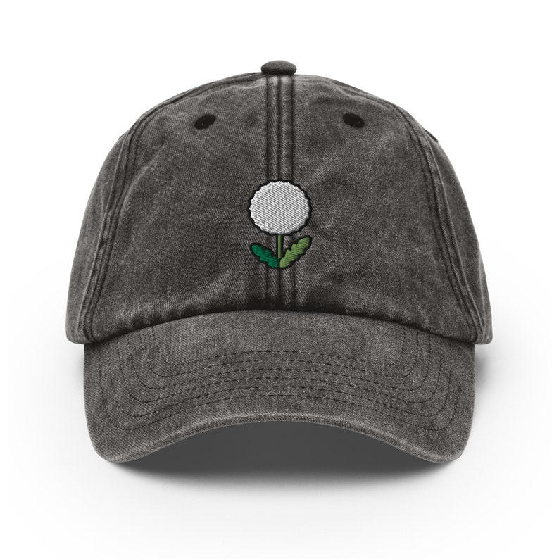 May include: A black vintage washed cotton baseball cap with an embroidered white dandelion design.