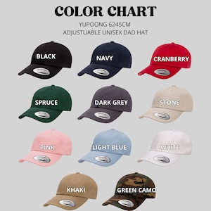 K&ouml;nnte beinhalten: Farbkarte mit 12 verschiedenen Farben von verstellbaren Unisex-Dad-Caps. Die Farben sind: Schwarz, Marine, Cranberry, Fichte, Dunkelgrau, Stein, Rosa, Hellblau, Wei&szlig;, Khaki und Gr&uuml;n-Camouflage.