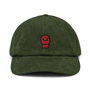 May include: A green corduroy baseball cap with a red boxing glove embroidered on the front.