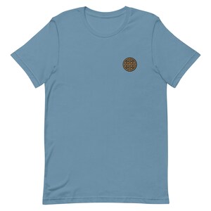 Op de afbeelding: Een lichtblauw T-shirt met korte mouwen en een bruine wafelprint.