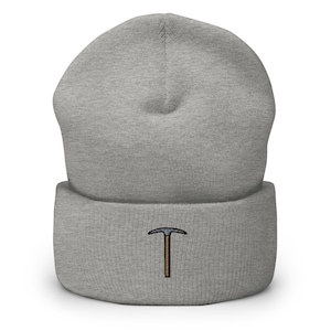 Op de afbeelding: Grijze beanie met een klein geborduurd ontwerp van een pickaxe.