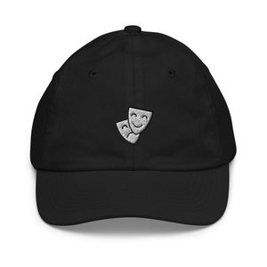 Peut inclure: Une casquette de baseball noire avec un motif brodé blanc de deux masques théâtraux, l'un souriant et l'autre renfrogné.