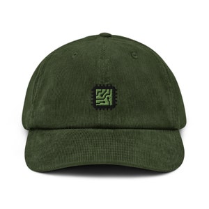 Può includere: Un cappello da baseball in velluto a coste verde con un design di circuito stampato ricamato in nero e verde.