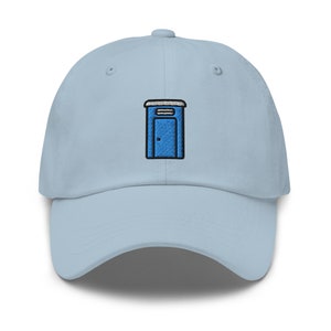 May include: A light blue baseball cap with an embroidered blue portable toilet design.