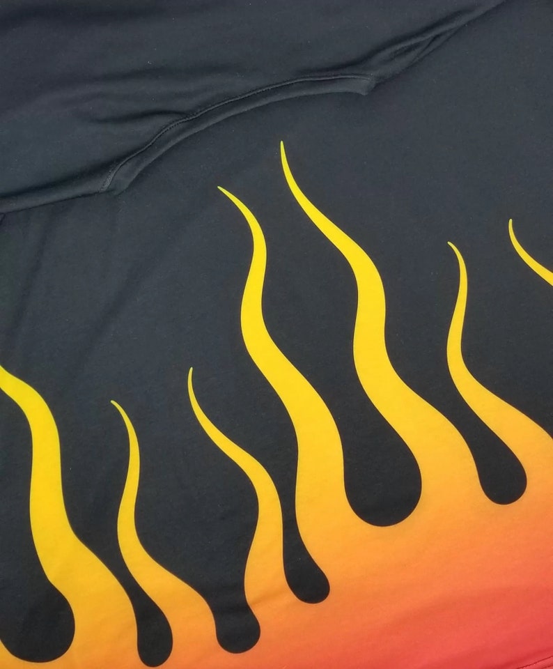 Puede incluir: Tela negra con un dise&ntilde;o de llamas amarillas y naranjas. Las llamas son estilizadas y tienen un efecto degradado.