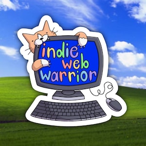 May include: A sticker featuring a cartoon orange cat peering over a vintage computer monitor. The screen displays the colorful text indie web warrior in a playful font. A black keyboard and a computer mouse with a cord are attached to the monitor.