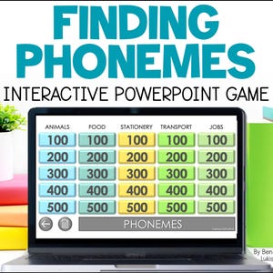 May include: A laptop screen displaying a PowerPoint game called "Finding Phonemes". The game features a grid with five columns labeled "Animals", "Food", "Stationery", "Transport", and "Jobs". Each column has five rows with numbers 100, 200, 300, 400, and 500. The game is designed to help students learn about phonemes.