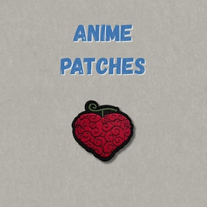 May include: An embroidered patch featuring a red heart-shaped fruit with a black outline and a small green stem. Above the patch, the text ANIME PATCHES is printed in blue capital letters against a light gray background.