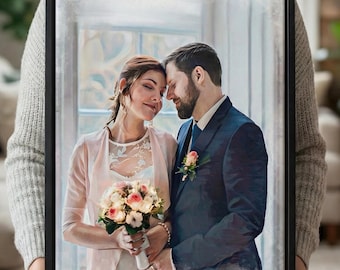 May include: A framed canvas print featuring a couple embracing, with the text "Jessi & Sven 28.12.2018" in a script font. The couple is dressed in wedding attire, with the woman holding a bouquet of pink and white flowers. The frame is black.