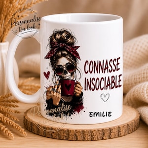 Puede incluir: Taza de cerámica blanca con un diseño de calavera con gafas de sol y una bandana roja. La taza tiene las palabras "CONNASSE INSOCIABLE" y el nombre "EMILIE" impresos. También hay un diseño de corazón.