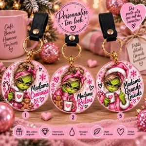 Peut inclure: Trois porte-clés circulaires en acrylique avec lanières en cuir noir et anneaux dorés. Chaque pièce présente une illustration de personnage vert en tenue rose avec le texte : Madame Connasse, Madame Relou et Madame Grande Gueule, orné de cœurs et flocons.