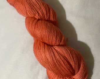 May include: A skein of coral-colored yarn, perfect for knitting or crocheting.